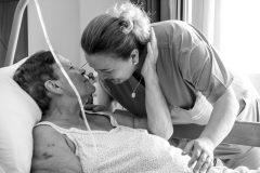 Una paziente abbraccia l'infermiera che la sta curando